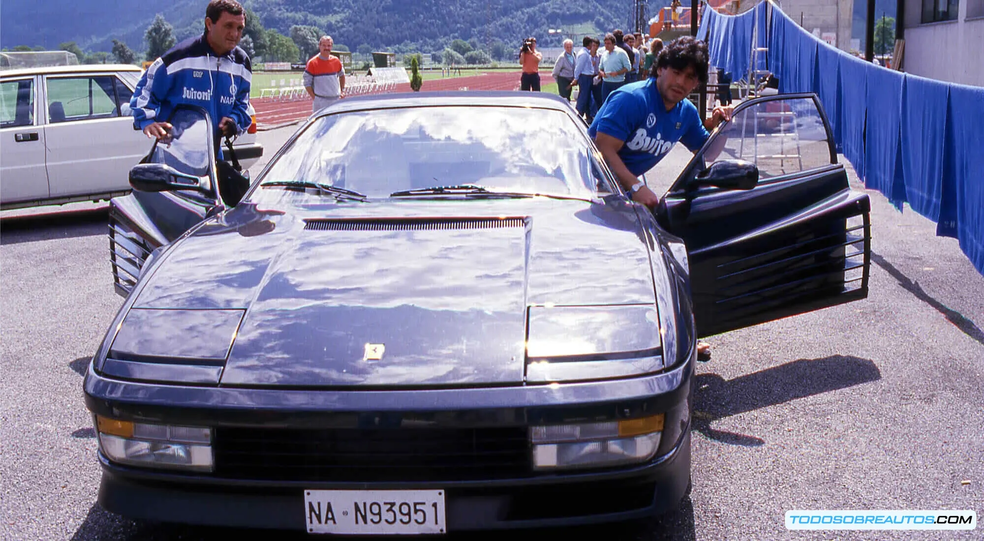 Diego Maradona junto a un Ferrari Testarossa negro.