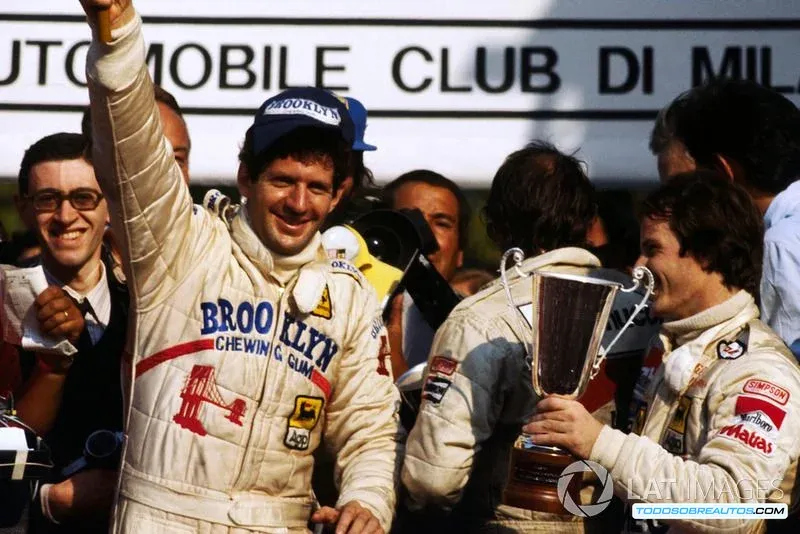 Imagen de un piloto de Ferrari de épocas pasadas con un mono blanco y azul.