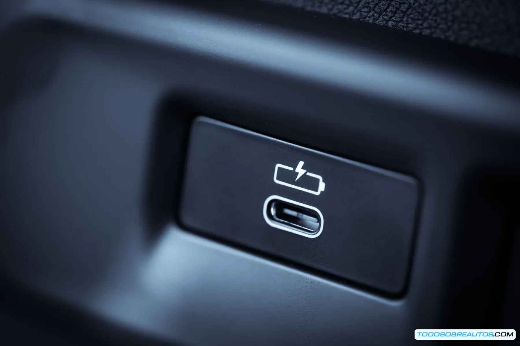 Imagen de un puerto USB en un coche, destacando su posible insuficiencia para cargar móviles modernos.