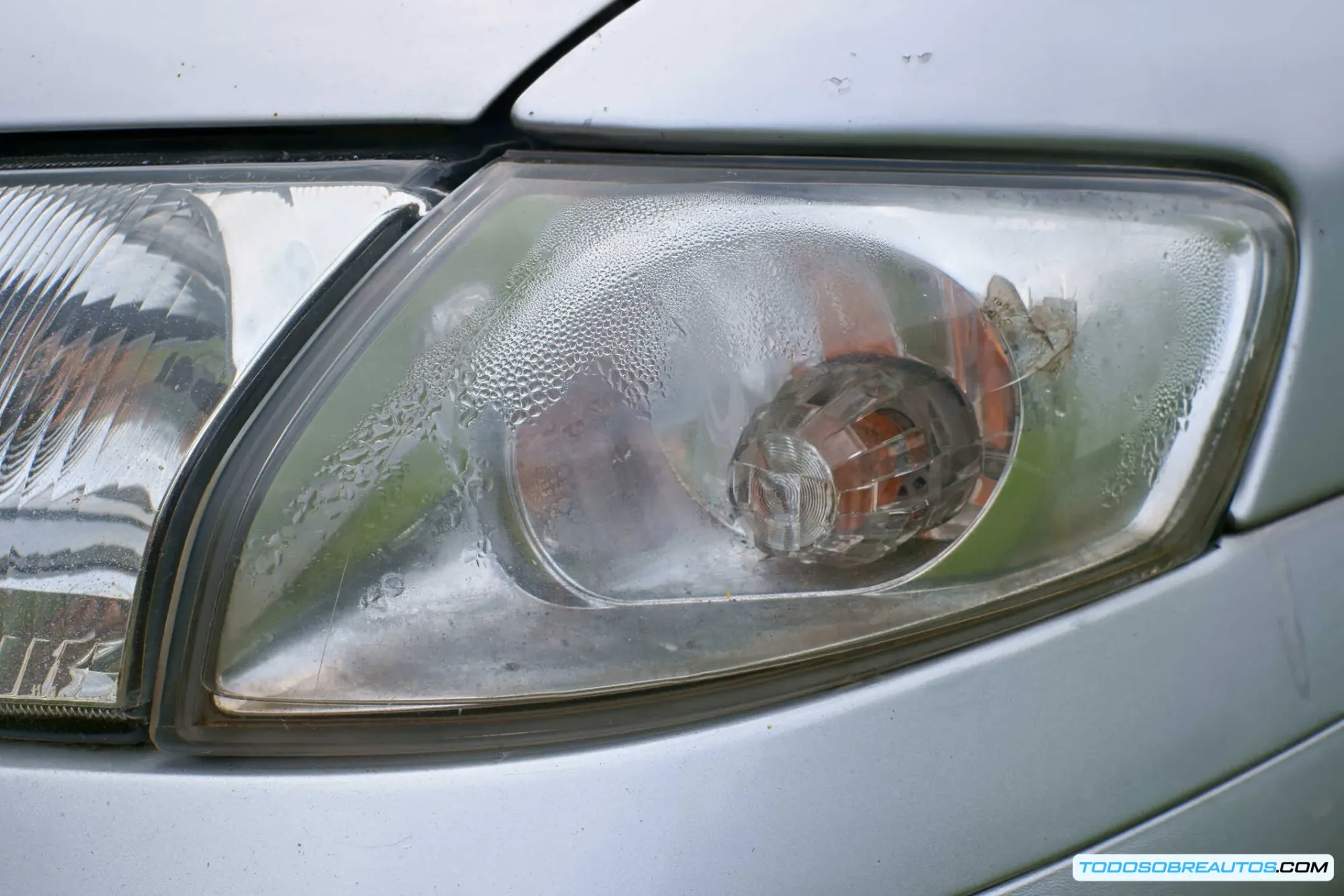 Imagen de un faro de coche con condensación o agua en su interior.