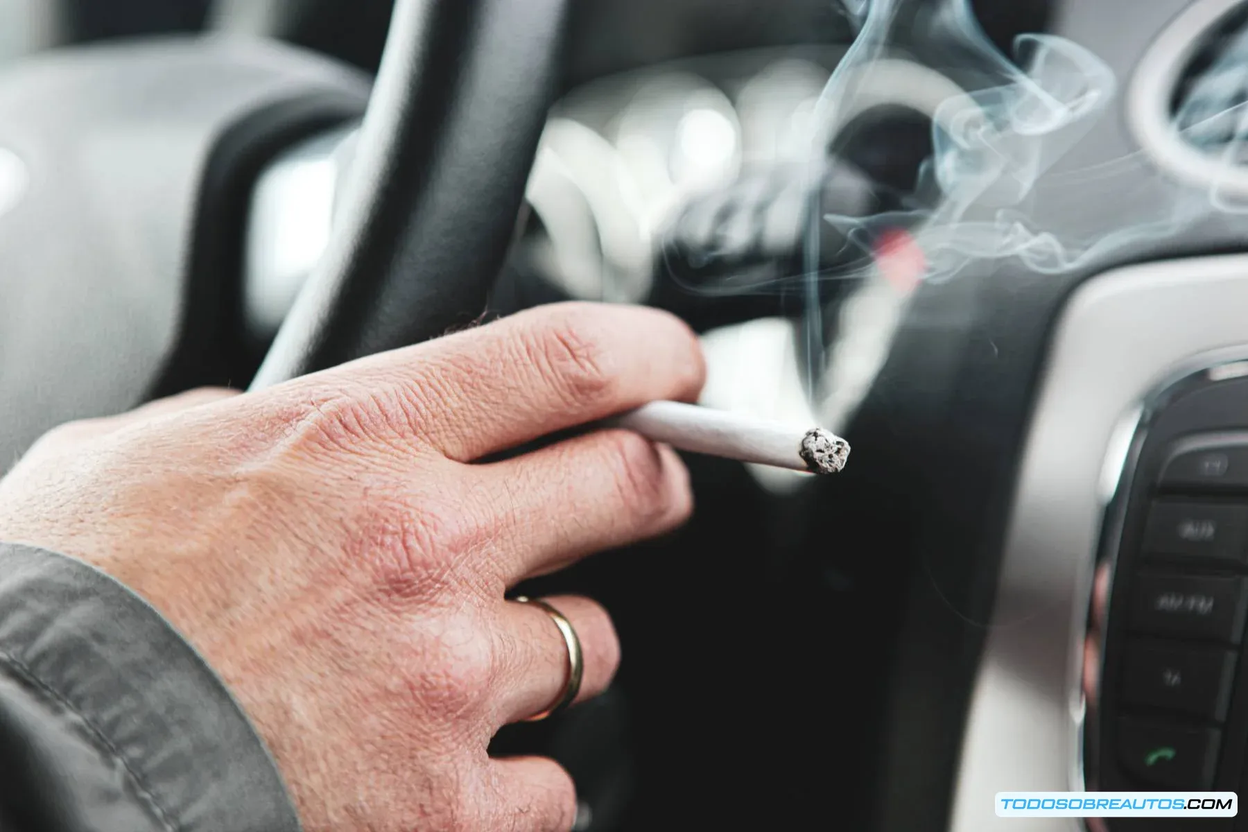 Un conductor fumando al volante, mostrando una distracción al conducir.