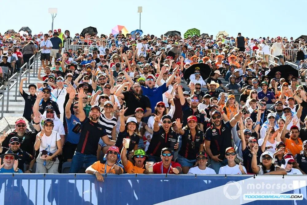 Aficionados emocionados en una tribuna de un circuito de Fórmula 1.