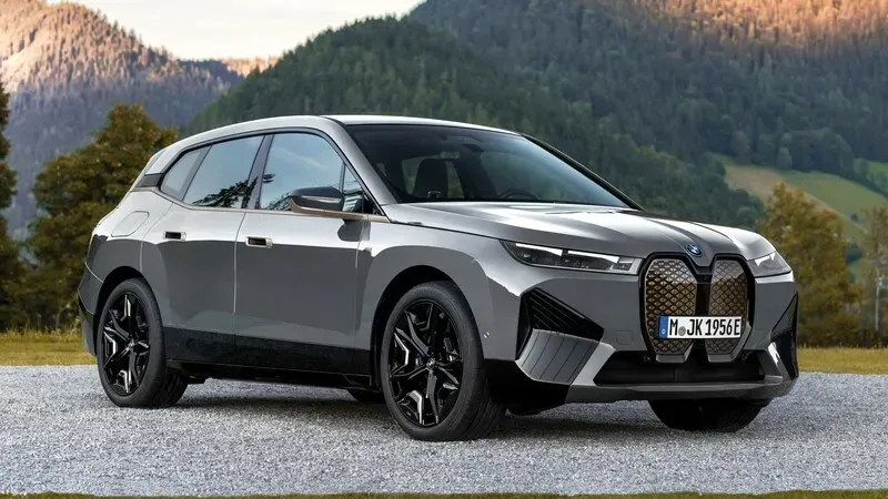BMW iX: Un SUV eléctrico gris con un diseño audaz en un entorno montañoso.