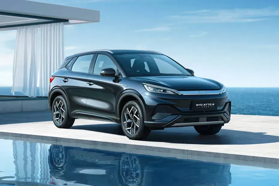 Este Vehículo SUV de color negro, diseño elegante y aerodinámico.Presentado sobre una plataforma cerca de una piscina, sugiriendo un ambiente lujoso.