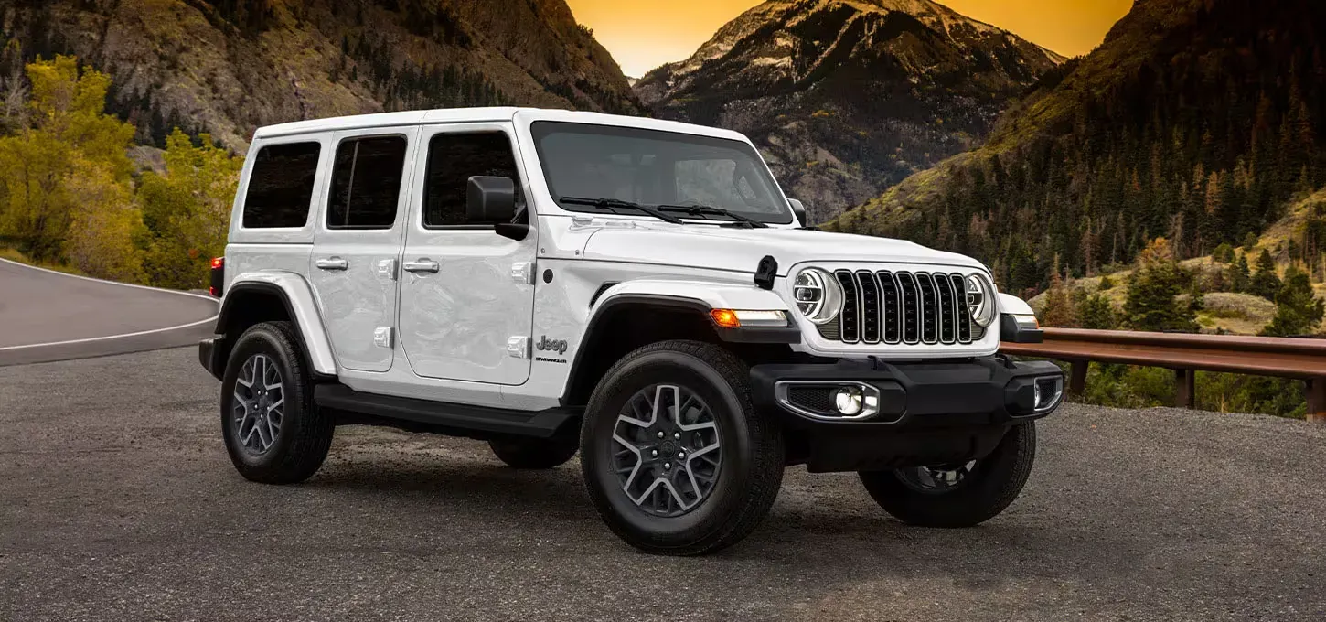 Un jeep Wrangler blanco estacionado en una carretera montañosa.