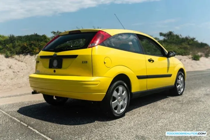Ford Focus ZX3 Mk1 amarillo de 2002, vista trasera tres cuartos.