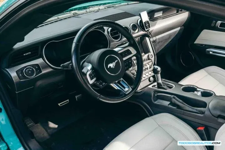 Interior del Mustang EcoBoost SEMA 2021, mostrando los asientos de cuero blanco y costuras naranjas.