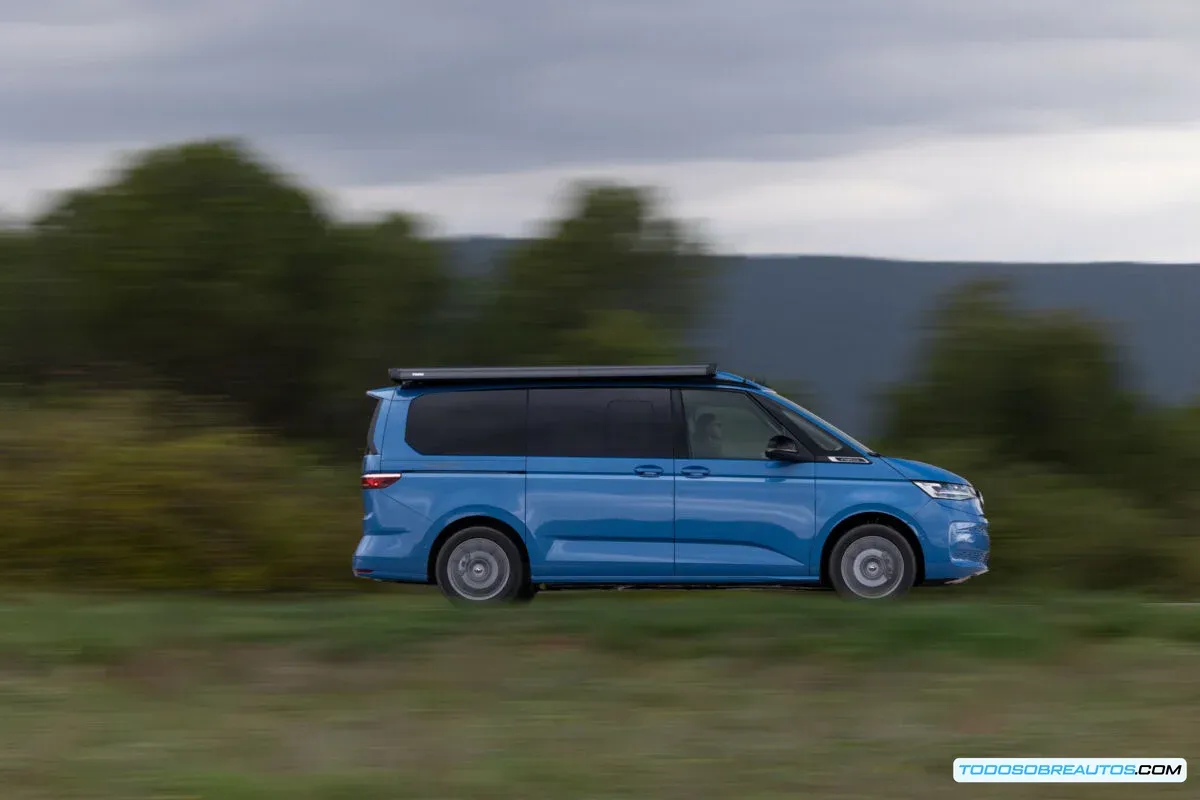Configuración interior de la VW California T7 e-Hybrid con asientos giratorios y mesa.
