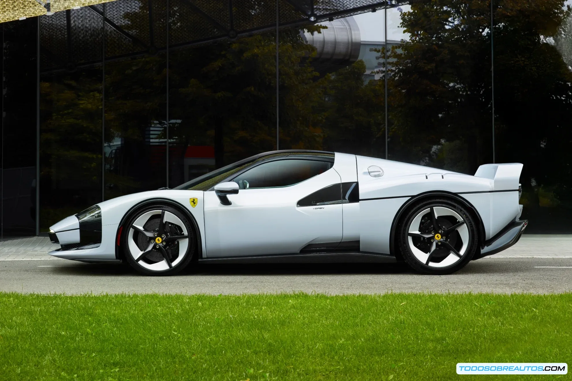 Vista lateral del Ferrari SC40 mostrando su diseño y la silueta del F40 de fondo.