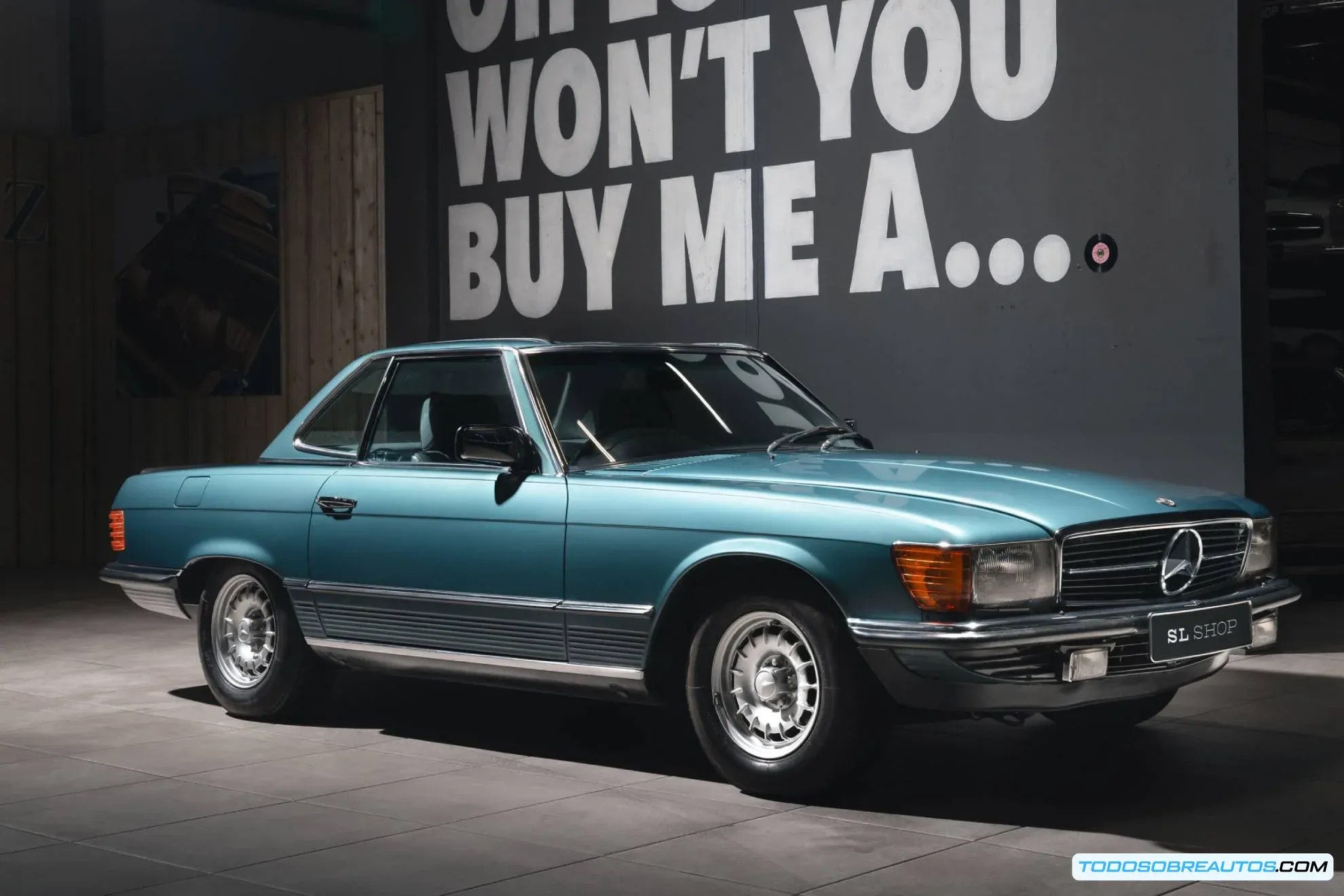Detalle del interior impecable de un Mercedes Benz 500 SL R107 de 1983 sin uso, mostrando el salpicadero, asientos de cuero y volante original.