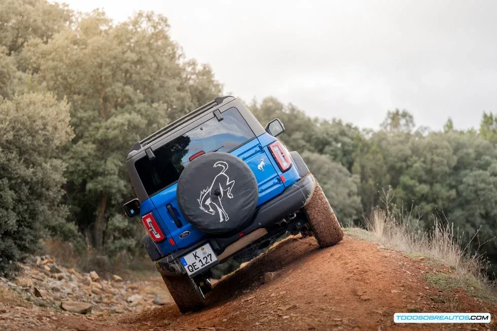 Dos vehículos todoterreno, uno remolcando al otro con un cable de remolque en un camino rural, ilustrando una situación de asistencia en carretera.