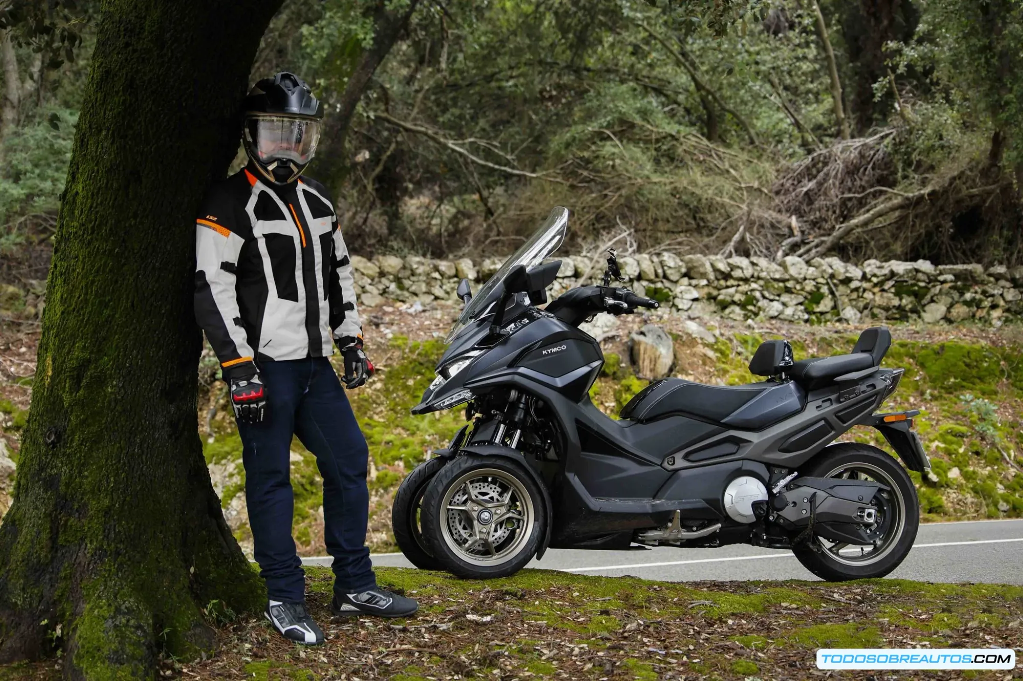 Kymco CV3 estacionado en entorno urbano mostrando su tamaño compacto ideal para aparcar en la ciudad junto a automóviles