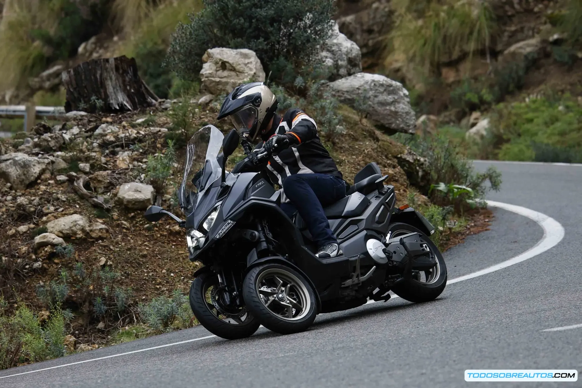 Compartimento bajo asiento del Kymco CV3 abierto mostrando espacio para casco integral y maletas laterales opcionales con 133 litros de capacidad