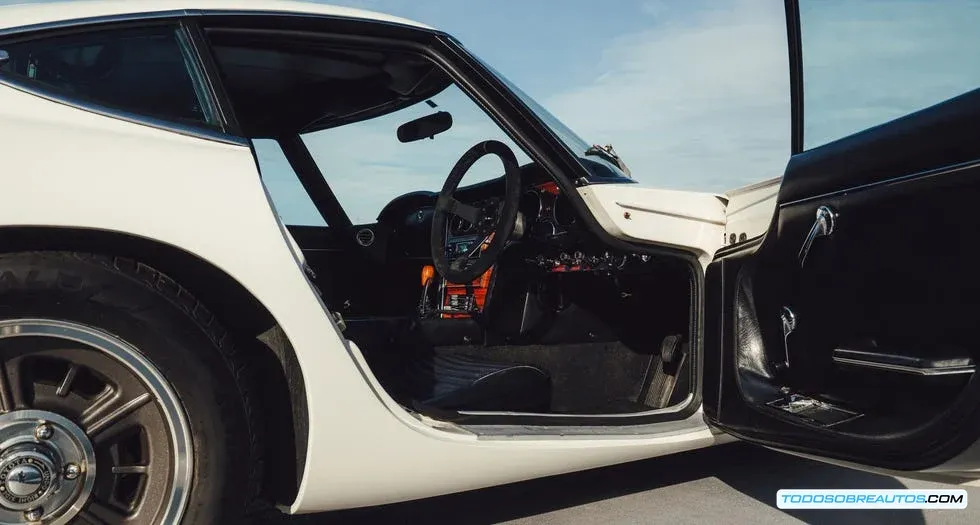 Interior del Toyota 2000 GT mostrando la palanca de cambios de la transmisión manual de 5 velocidades y el tablero de instrumentos clásico