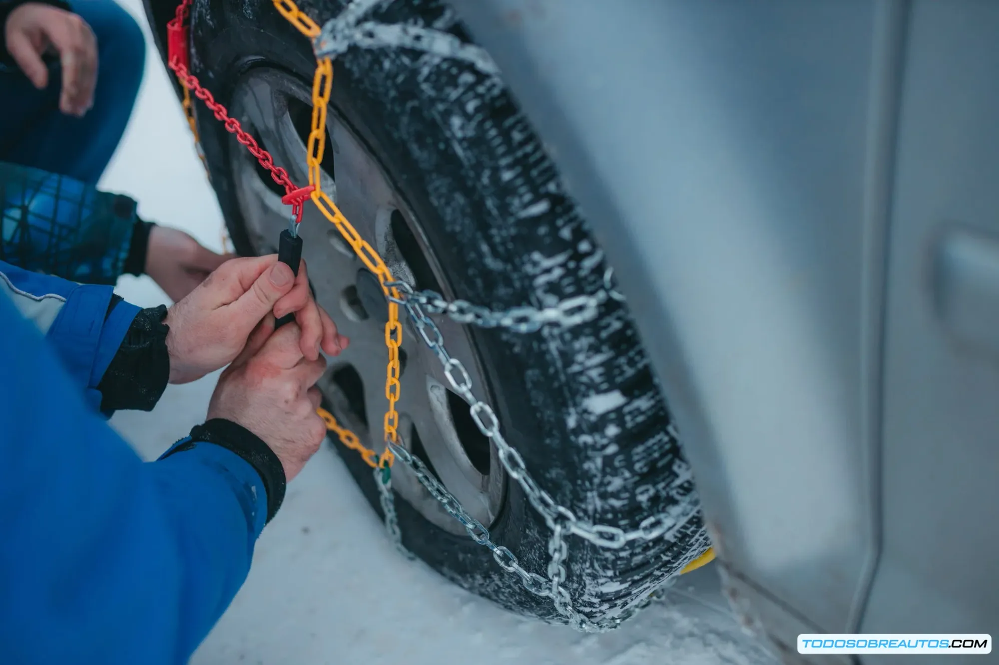 Personas instalando cadenas de nieve en coche, demostración práctica para conductores 2025
