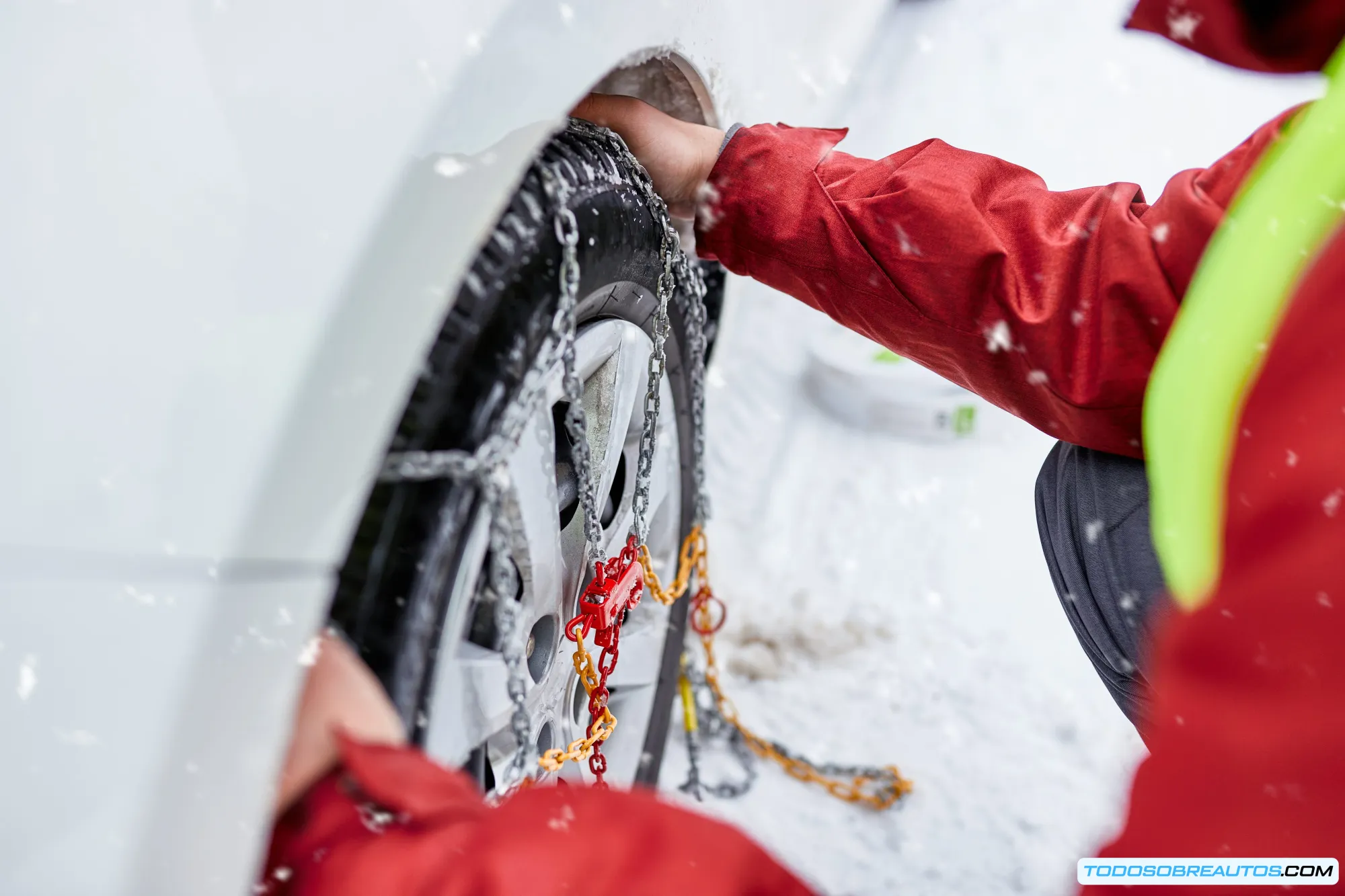 Coche recibiendo ayuda en carretera durante condiciones invernales que requieren cadenas de nieve