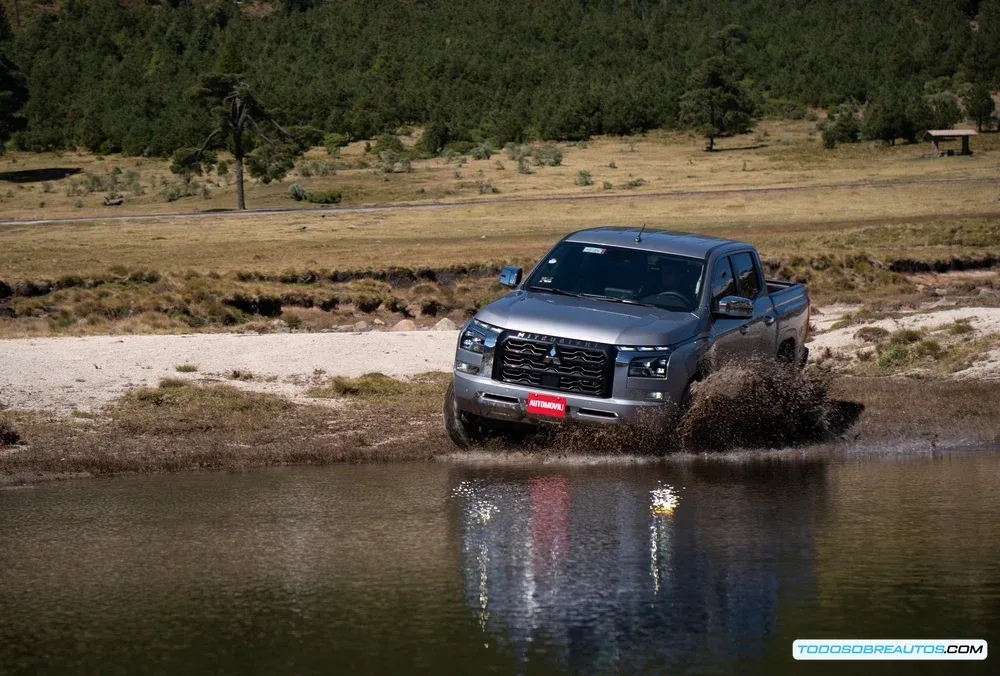 Vista de la batea de la Mitsubishi L200 2025 mostrando su área de carga y ganchos de sujeción.