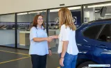 Imagen de un mecánico hablando amablemente con un cliente en un taller mecánico.