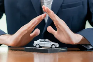 Persona con traje colocando manos sobre auto a escala plateado 