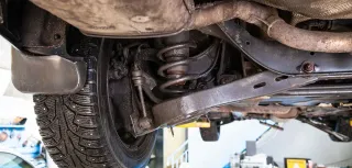 Auto elevando en plataforma mostrando chasis y suspensión 