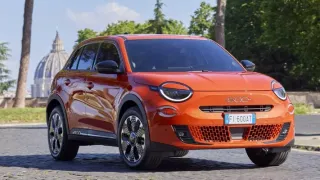 El auto es de un vibrante color naranja. Tiene un diseño moderno y compacto, sugerente de un SUV.